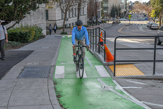 A person riding a bike. The Corridor Access Plan will help identify strategies for getting to and from BART in many ways, such as by riding a bike.