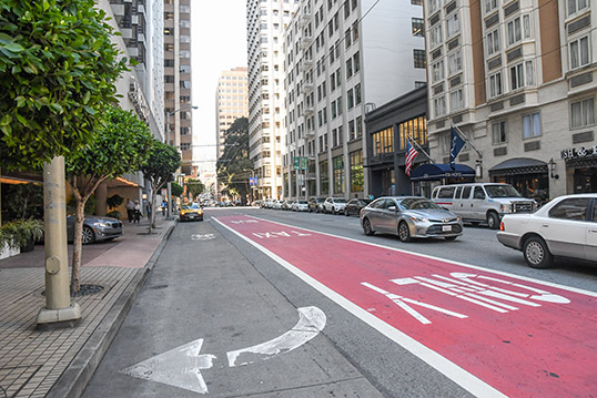Image of dedicated bus lane shown in red paint, as an example of how changes to the street design can enhance bus reliability. 